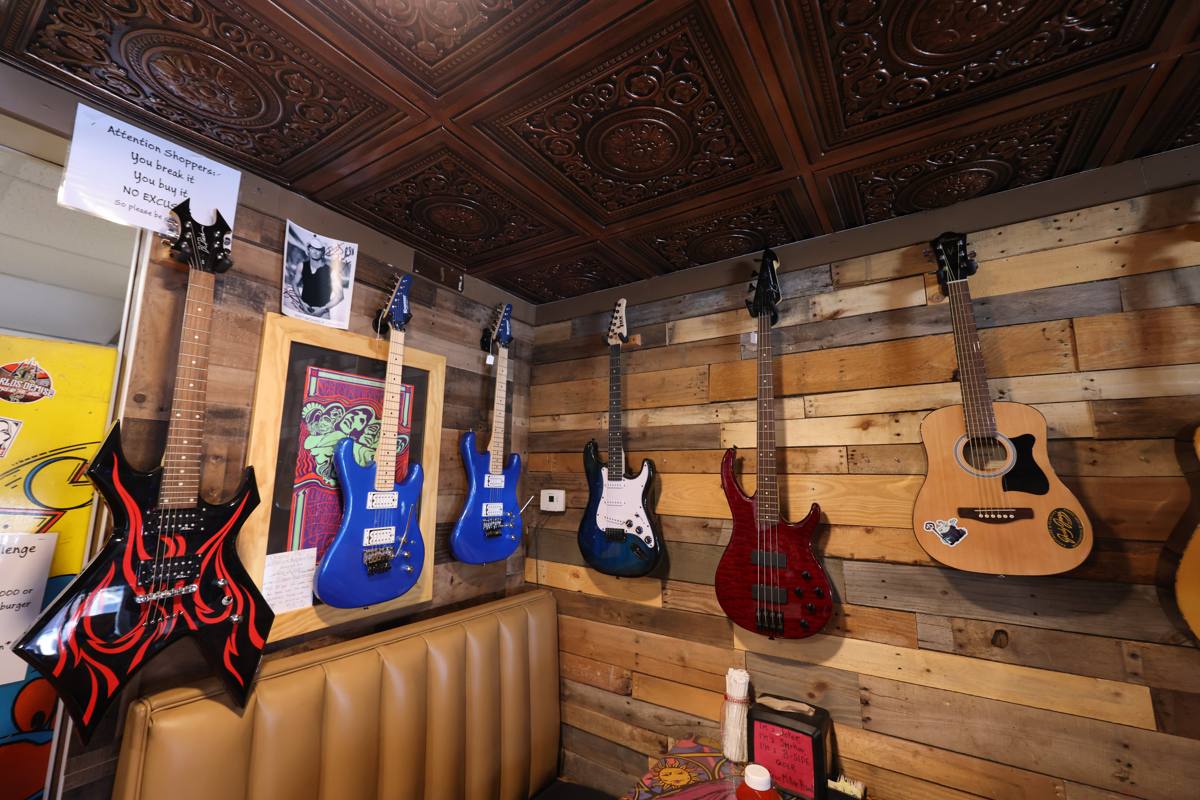 Full guitar wall display with electric and acoustic guitars